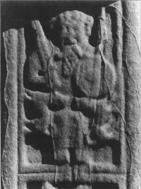 Plate 1: Seated chief bearing upright sword, circular shield and spear under the arm: south face of the high cross at Durrow, County Offaly. (COURTESY OF THE OFFICE OF PUBLICWORKS)