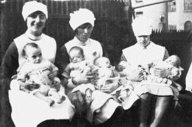 Infants (l–r) Betty, George, Jack, Kate and Joseph with unnamed nurses, March 1929. (Teach Ultáin Infant Hospital)