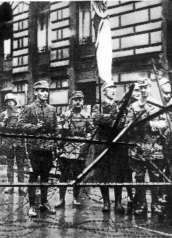 Heinrich Himmler, future leader of the SS, holds the German imperial flag behind a barricade during the 1923 Munich ‘beer hall’ putch. The putsch was doomed, but it enabled Nazis to claim a central place in the martyrology of national resistance and endowed them with a powerful founding myth. (Ullstein Bilderdienst)