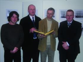 Members of the Waterford County Museum Image Archive project team perusing a recently donated album of photographs (l to r)—image archivist Alan Healy, Museum president Willie Whelan, curator Willie Fraher and Déise Design software developer Martin Whelan. (Waterford County Museum)