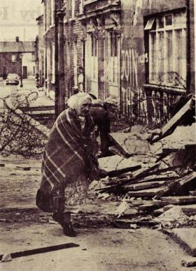 The aftermath—an old woman surveys the wreckage on the Falls Road. (Belfast News Letter) 