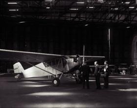 ‘Wrong Way’ Corrigan’s 1929 Curtiss Robin OX-5 monoplane in the hanger at Baldoyle aerodrome after his ‘accidental’ non-stop solo flight from New York in July 1938. The photograph is part of the ‘Trains, Planes and Automobiles’ exhibition at the National Photographic Archive, Temple Bar, Dublin, which runs until the end of October 2008. (National Library of Ireland)