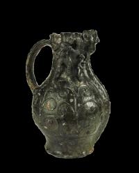 Found in excavations at High Street, Dublin, this elaborate green-glazed wine jug was made in the pottery kilns of Redcliffe, near Bristol, in England.