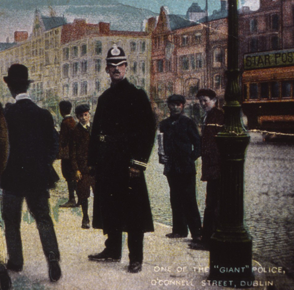 Above: A colourised postcard of ‘ONE OF THE “GIANT” [DMP] POLICE, O’CONNELL STREET, DUBLIN’, shortly before the force was absorbed into the Garda Síochána in 1924–5.